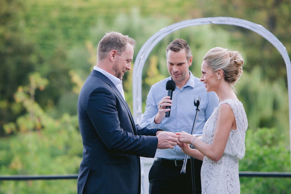 bride puts ring on grooms finger